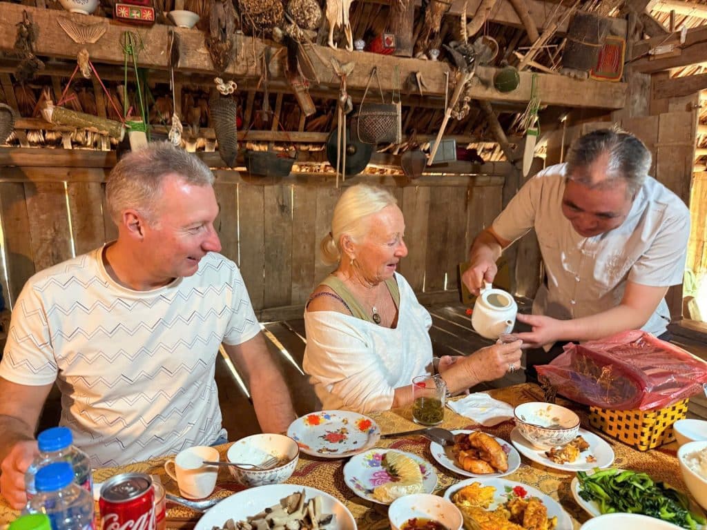 Voyageurs partageant un repas traditionnel chaleureux avec leur famille d'accueil au Vietnam