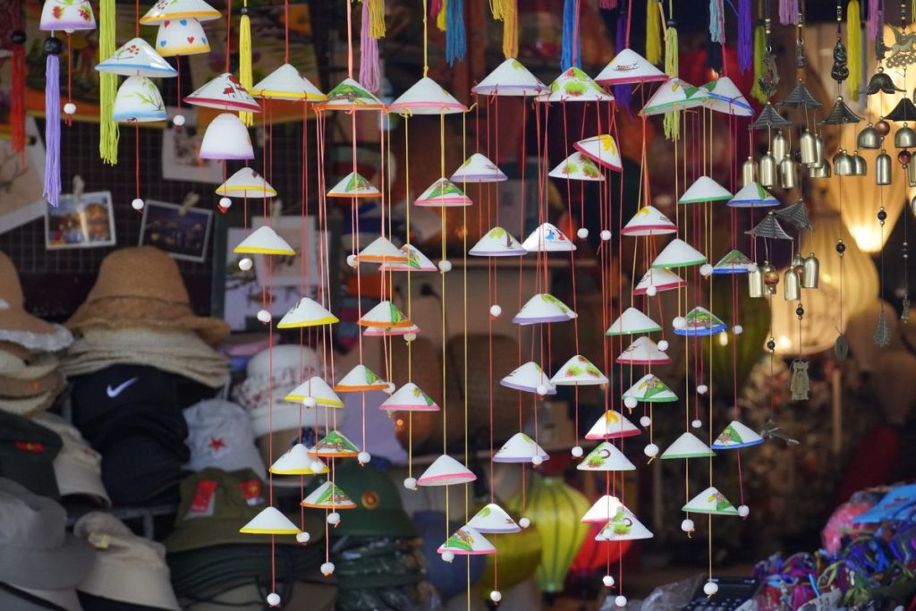 Étal de chapeaux coniques et d’objets décoratifs sur un marché couvert au Vietnam